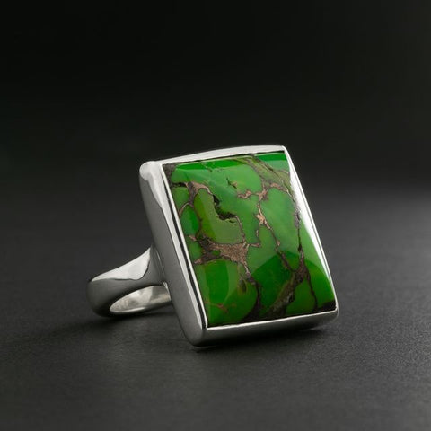 Silver ring with a green turquoise on a dark background