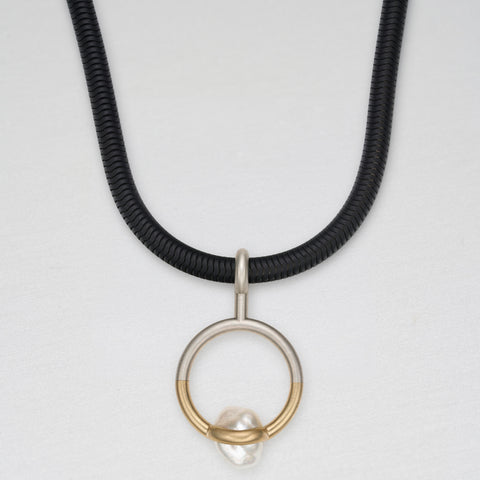 Silver, gold and trapped pearl pendant on black stainless steel chain