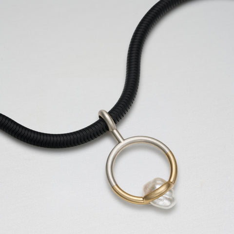 Silver, gold and trapped pearl pendant on black stainless steel chain