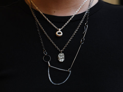 Close-up of layered necklaces on a black background