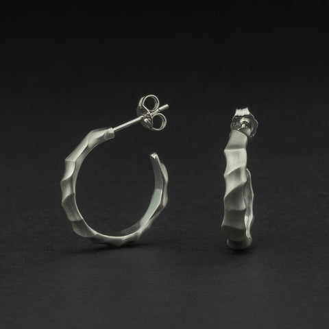 Pair of silver hoop earrings on a dark background
